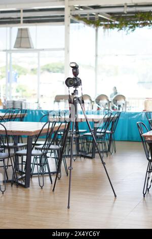 Canon DSLR-Kamera mit externem Blitz, montiert auf einem Stativ in einem Restaurant Stockfoto