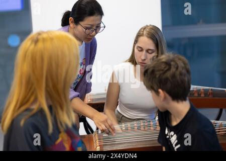 Belgrad, Serbien. April 2024. Ein Lehrer (L, hinten) unterrichtet während eines Guzheng-Kurses im China Cultural Center in Belgrad, Serbien, 29. April 2024. Das China Cultural Center in Belgrad, das gemeinsam vom chinesischen Ministerium für Kultur und Tourismus und der Provinzregierung von Shandong errichtet wurde, wurde kürzlich für die Öffentlichkeit geöffnet. Das Zentrum erstreckt sich über eine Fläche von 6.000 Quadratmetern und bietet Kurse in chinesischer Sprache, traditionellen chinesischen Musikinstrumenten, chinesischer Kalligraphie und Tai Chi an. Quelle: Li Jing/Xinhua/Alamy Live News Stockfoto