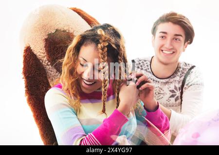 Zwei Freunde oder Geschwister in farbenfroher Kleidung spielen mit Spielzeug und Ballons und schaffen eine fröhliche und lustige Atmosphäre Stockfoto