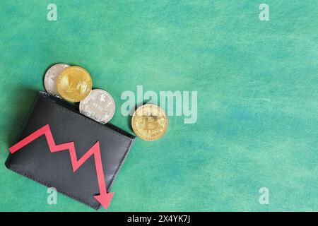 Eine schwarze Brieftasche mit Bitcoin und rotem Pfeil nach unten. Kryptowährungen, Bärenlauf und Preissenkungskonzept. Stockfoto