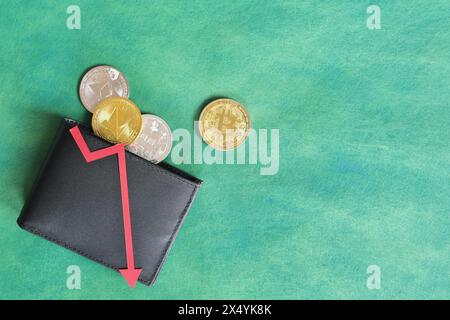 Eine schwarze Brieftasche mit Bitcoin und rotem Pfeil nach unten. Kryptowährungen, Bärenlauf und Preissenkungskonzept. Stockfoto