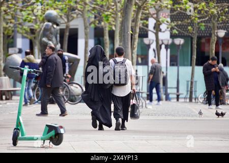 Frankfurt am Main, Deutschland, 05. Mai 2024. Ein muslimisches Paar geht auf den Straßen von Hauptwache, die Frau trägt ein schwarzes Kleid, das das Gesicht bedeckt. Stockfoto