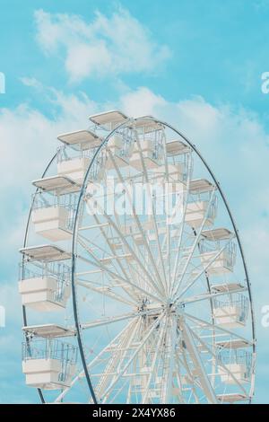Das Riesenrad für Panoramablick im Vergnügungspark ist beliebte unterhaltsame Fahrt, die am hellen sonnigen Tag am Sommerhimmel gedreht wird, selektiver Fokus Stockfoto