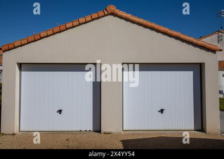 Geschlossene Rollladentür Roller zwei weiße Metall Garage 2 Tor in der Hausfassade Wand Straßeneingang Stockfoto