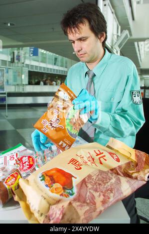 Medizin, Virus, H5N1, Vogelgrippegefahr, Zollbeamter Flughafen München mit angehaltenem Essen, ADDITIONAL-RIGHTS-CLEARANCE-INFO-NOT-AVAILABLE Stockfoto