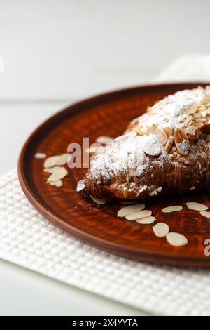 Mandelcroissant auf Tonplatte Nahaufnahme Stockfoto