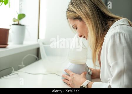 Frau hat eine schlimme Erkältung und versucht eine Therapie mit einem Inhalator Stockfoto