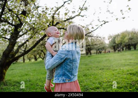 Porträt einer schönen, erwachsenen Mutter mit Kleinkind im Freien in der Natur des Frühlings. Stockfoto