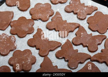 Auf dem Backblech lagen Zuschnitte zum Backen von Lebkuchen. Sie sind auf Essenspapier. Lebkuchen kochen. Stockfoto