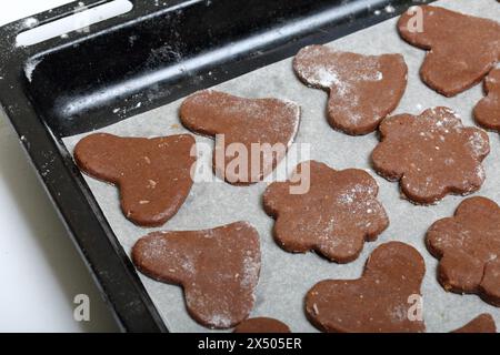 Auf dem Backblech lagen Zuschnitte zum Backen von Lebkuchen. Sie sind auf Essenspapier. Lebkuchen kochen. Stockfoto