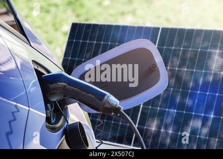 Elektroauto-Elektrofahrzeug, das von einem Solarpanel im Freien aus aufgeladen wird Stockfoto