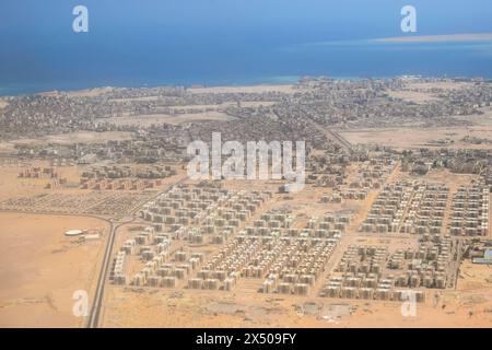 Luftaufnahme der Küstenstadt am Roten Meer. Blick auf die Küstenstadt mit klarem blauem Wasser und atemberaubendem Barriereriff, blauem Dunst. Ägypten, Hurghada. Kopieren Stockfoto