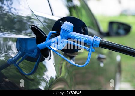 Nahaufnahme eines Brennstoffzellenwagens mit angeschlossener Wasserstoffbetankungsdüse Stockfoto