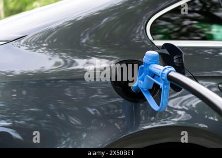 Nahaufnahme eines Brennstoffzellenwagens mit angeschlossener Wasserstoffbetankungsdüse Stockfoto