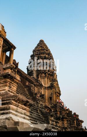 Ein detaillierter Blick offenbart die komplizierte Schönheit eines der Tempel von Angkor Wat, der stolz vor dem Hintergrund des klaren blauen Himmels steht. Stockfoto