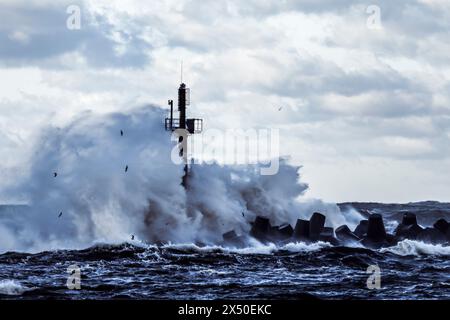 Sturmwellen stürzen gegen den Wellenbrecher im Hafen von Klaipeda, Litauen Stockfoto