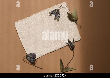 Blick von oben auf ein leeres Stück hausgemachte Deckelkantenkarte mit Blumen auf einem Holztisch Stockfoto