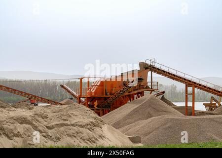 Betonproduktionsanlage. Haufen von zerquetschtem Stein und Sand. Stockfoto