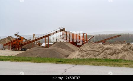 Betonproduktionsanlage. Haufen von zerquetschtem Stein und Sand. Stockfoto