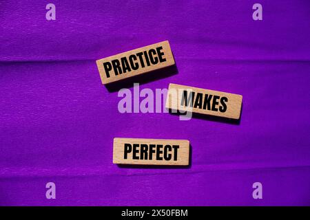 Die Praxis macht perfekte Wörter, die auf Holzblöcken mit violettem Hintergrund geschrieben werden. Konzeptionelle Praxis ist das perfekte Symbol. Kopierbereich. Stockfoto
