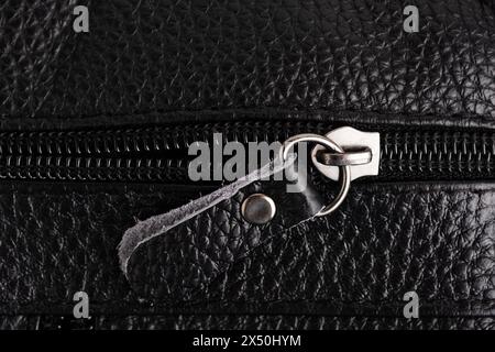 Reißverschluss an schwarzer Ledertasche. Nahaufnahme der schwarzen Ledertasche Stockfoto