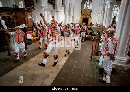 Thaxted, England Gb Mai 2024. Thaxted Essex UK May Day Morris Dancing in Thaxted Church 6 Mai 2024 Thaxted Morris Side (Red and White Stripes) und Blackmoore Morris Side in Blue spielen ungewöhnlich ihren traditionellen May Day Morris Dancing Set in der Thaxted Church aufgrund des schlechten Maiday Wetters. Conrad Noel (12. Juli 1869 bis 22. Juli 1942), ein christlicher Sozialist, bekannt als der „Rote Vikar“ von Thaxted, half zusammen mit Cecil Sharp, 1934 bei der Wiedergründung des Morris-Rings in Thaxted Credit: BRIAN HARRIS/Alamy Live News Stockfoto