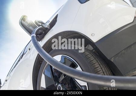Laden von Elektrofahrzeugen für Elektrofahrzeuge sauberer Energie für die Zukunft. Nahaufnahme in sonnigem blauem Himmel Stockfoto