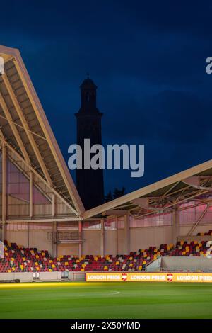 Blick in die Dämmerung über den Platz mit Blick auf das London Museum of Water and Steam. Brentford Community Stadium, Brentford, Vereinigtes Königreich. Architekt Stockfoto