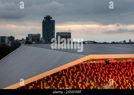 Blick in die Dämmerung über die Stände, die die städtische Lage zeigen. Brentford Community Stadium, Brentford, Vereinigtes Königreich. Architekt: AFL Architects, 2020. Stockfoto