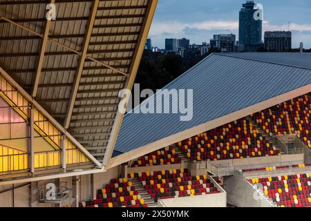 Blick in die Dämmerung über die Stände, die die städtische Lage zeigen. Brentford Community Stadium, Brentford, Vereinigtes Königreich. Architekt: AFL Architects, 2020. Stockfoto