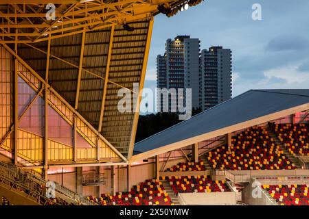 Blick in die Dämmerung über die Stände, die die städtische Lage zeigen. Brentford Community Stadium, Brentford, Vereinigtes Königreich. Architekt: AFL Architects, 2020. Stockfoto