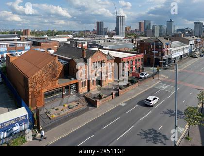 Luftaufnahme des Manchester Jewish Museum (und der umliegenden Gebäude) an der Cheetham Hill Road, Manchester, Großbritannien. Autos fahren vorbei und die Destillation des Museums Stockfoto