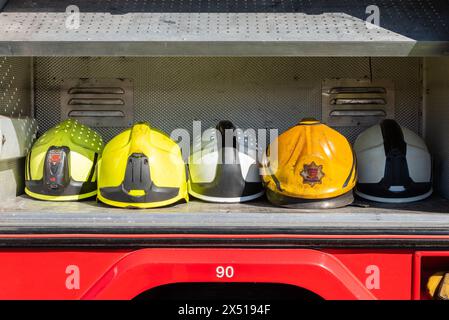 Auswahl an Helmen in Feuerwehrfahrzeugen, Feuerwehrgeräten bei der Enthüllung und Eröffnung des National Red Plaque Fire Service Memorial in Rettendon, Essex, Großbritannien Stockfoto