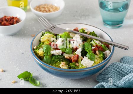 Gesunder Brokkoli-Salat mit Feta-Käse, getrockneten Tomaten, Pinienkernen. Vegetarische Low Carb Keto-Diät Stockfoto