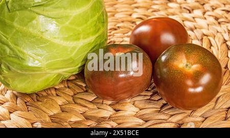 Rote Tomaten und Kohl auf einer Rattanmatte Nahaufnahme Stockfoto