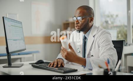 Afroamerikanischer Familienarzt verschreibt einem Patienten Medikamente. Arzt empfiehlt Pillen in einer Box einem Patienten in einer Gesundheitsklinik. Arzt sitzt hinter einem Schreibtisch im Krankenhausbüro. Stockfoto