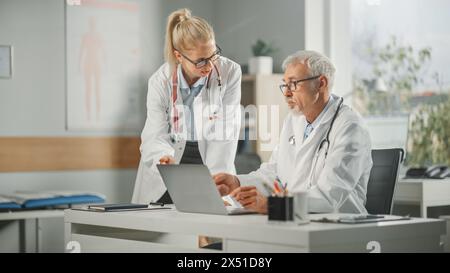 Arztpraxis: Arztpraxis spricht mit der professionellen Chefschwester am Desktop-Computer. Medical Health Care Specialists Diskutieren Testergebnisse, Verschreibungspflichtige Medizin, Patientenbehandlung Stockfoto