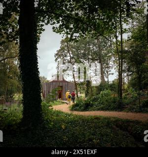 Der Bienenpavillon zwischen den Bäumen mit einem Pfad, der sich ihm zuwindet. Das Beezantium am Newt, Bruton, Vereinigtes Königreich. Architekt: Unsichtbare St Stockfoto