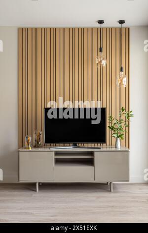 Fokussierter Blick auf den modernen TV-Ständer vor Holzpaneelhintergrund Stockfoto