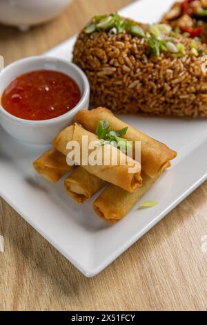 Gebratene Frühlingsbrötchen mit süßer Chili-Sauce und gebratenem Reis Stockfoto