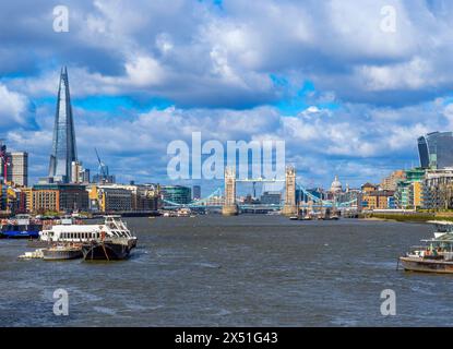 Blick auf die Tower Bridge und den Shard-Wolkenkratzer von der Themse mit Seefracht und Touristenfähren, die in der Sonne entlang des Flusses segeln Stockfoto