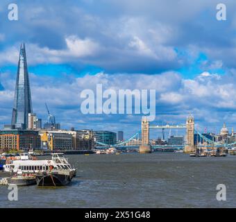 Blick auf die Tower Bridge von der Themse mit dem Shard Wolkenkratzer am Horizont und Schifffahrt und Touristenfähren, die entlang des Flusses o segeln Stockfoto