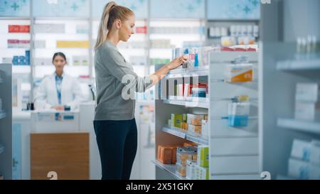 Apotheke Drugstore: Schöne kaukasische junge Frau entscheidet sich, Medizin, Medikamente, Vitamine zu kaufen, sucht Regale für die beste Wahl. Moderne Pharma Store Regale mit Gesundheitspflege, Beauty Produkte Stockfoto