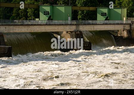 Wasserkraftwerk nach starkem Regen, mit schnell fließendem Wasser über das Wehr. Nahaufnahme. Stockfoto