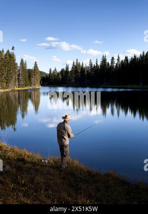 Ein Fliegenfischer versucht sein Glück in einem Bergsee in New Mexico. Stockfoto