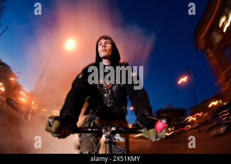 Fixed Gear Rider fährt nachts in Kapuzenpullover. Stockfoto