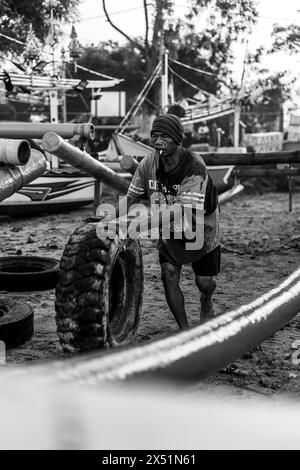 Fischer Rollen ein Fischerboot vom Wasser zum Ufer. Stockfoto
