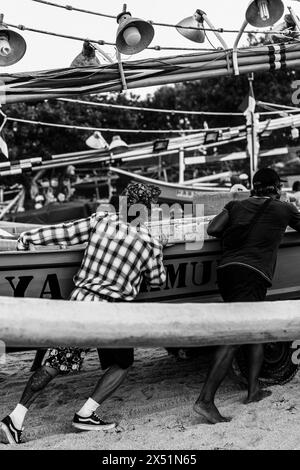 Fischer Rollen ein Fischerboot vom Wasser zum Ufer. Stockfoto