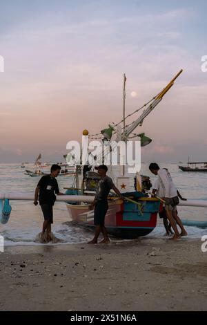 Fischer Rollen ein Fischerboot vom Wasser zum Ufer. Stockfoto