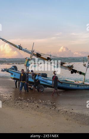 Fischer Rollen ein Fischerboot vom Wasser zum Ufer. Stockfoto